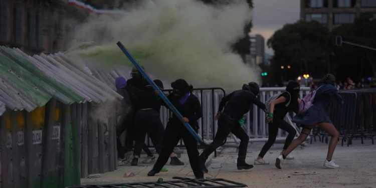 Durante su paso por el centro de Ciudad de México, las manifestantes destruyeron mobiliario urbano y agredieron con palos y herramientas a policías que custodiaban la protesta. (EFE)
