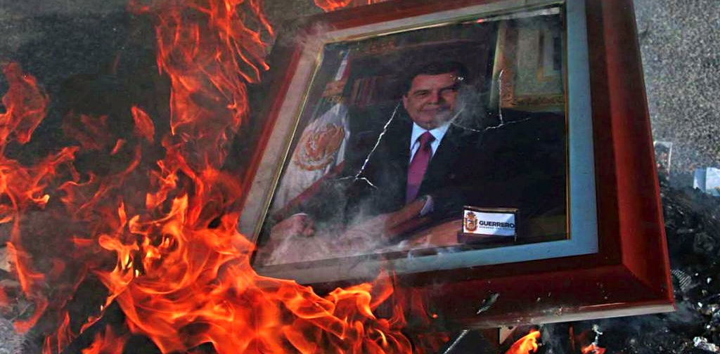 Manifestantes queman el retrato del gobernador Ángel Aguirre frente al palacio de Gobierno en Chilpancingo